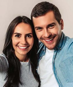 couple smiling after getting holistic general dentistry treatments